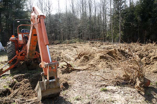 The backhoe and some of the stumps that were removed. The field in a rutted mess now.